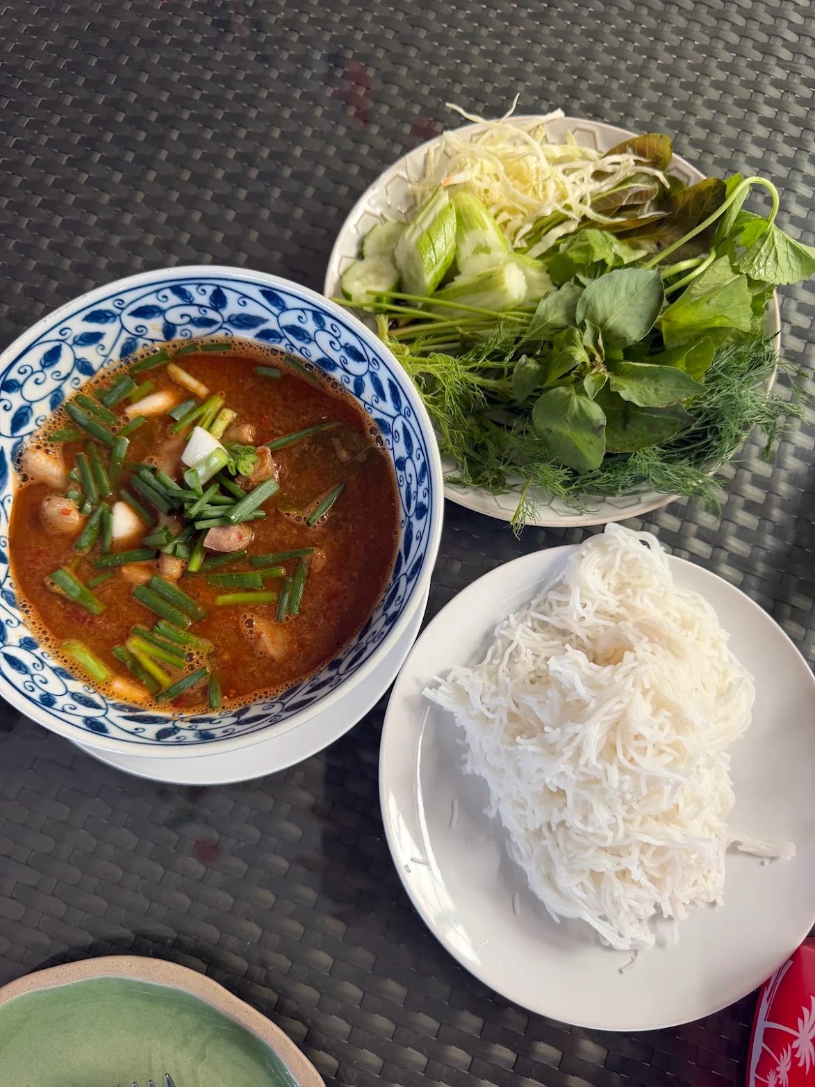 Thai dish served with fresh herbs and rice noodles